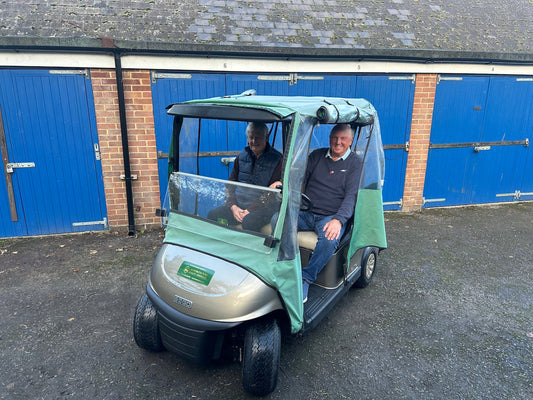 Two smiling golf club members on their shared 2021 EZGO RXV ELiTE buggy.