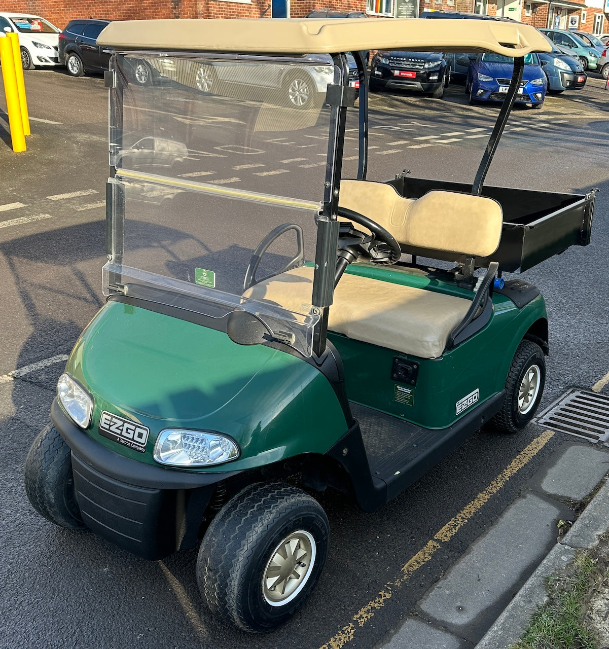 Green EZGO RXV with cargo box, lights and tow bar